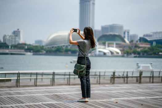 woman standing taking picture of scenery